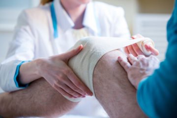 Man getting knee wrapped after a car accident.