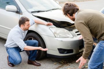 two men involved in car accident thinking what to do