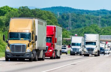 Convoy trucks passing in the interstate highway.