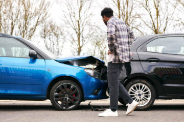 Driver checking for damages from rear-end collision.